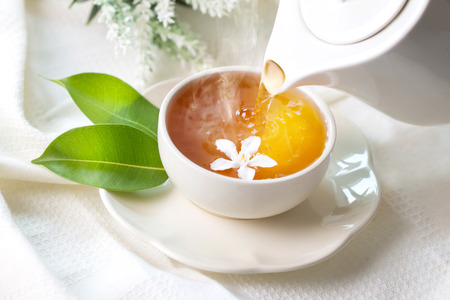Close up pouring hot jasmine tea in a white tea cup ,  Tea ceremony time conceptの写真素材