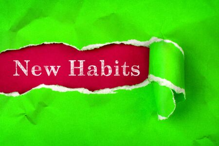Crumpled Torn vibrant green Paper and New Habits text with  a red paper backgroundの写真素材