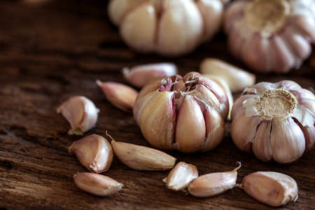 Close up garlic bulb in bowl on wooden tableの写真素材