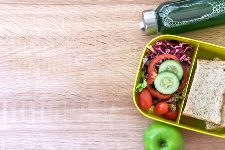 Healthy Lunch box with grain bread and green vegetable and fruit juice bottle on wooden background  ,Healthy eating clean food habits for diet concept , top view and overhead shotの写真素材