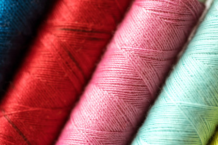 Close up multi color of bobbins threads roll as background