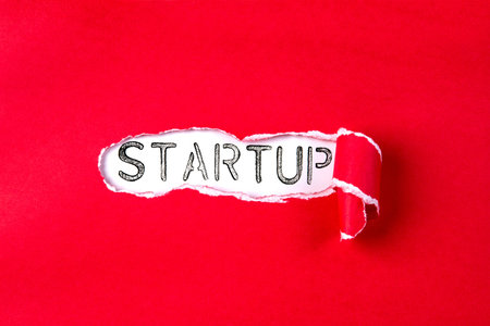 Torn red Paper and STARTUP text with a  white paper background