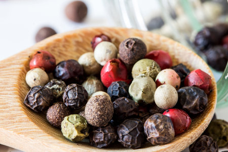Close up mixed type of peppercorns in wooden spoon 