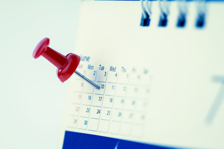 Red pushpin on calendar page for remind and marked important events , vintage retro color toneの写真素材