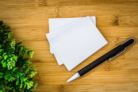 stacking of mockup empty white business card with elegance pen  on wooden background , template for business  branding identity designの写真素材