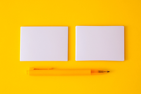 stacking of mockup empty white business card with elegance pen  on vibrant yellow background , template for business  branding  designの写真素材
