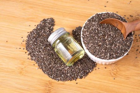 Close up Chia essential oil and seeds in wooden spoon , superfood and rich of nutrient an antioxidantの写真素材