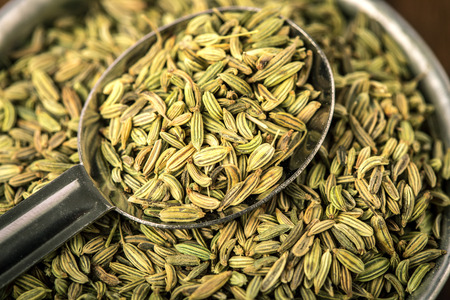 close up the fennel seed in  spoon on brown wooden tableの写真素材