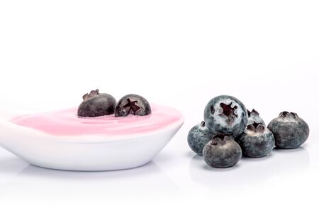 close up a pink creamy homemade blueberries fruit yogurt  on white backgroundの写真素材