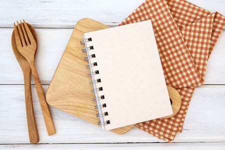 book notepad paper on chopping cutting board and tablecloth on white table, recipes food  for healthy habits shot note background conceptの写真素材