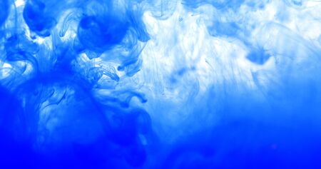 Close up  blue colored drop in the water, abstract motion movement of watercolor ink splashing as frame border backgroundの写真素材