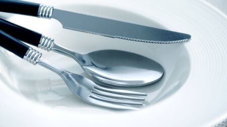 close up dinning the silverware fork, spoon and knife with dish on white background and text spaceの写真素材