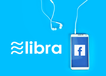 Bangkok Thailand, 08 - July 2019 : Libra coin cryptocurrency and blockchain on blue background with white smartphone, New digital currency by facebook conceptのeditorial素材