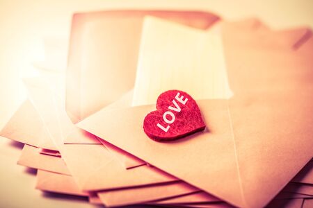 close up Stacking of pink envelopes and mail letter paper and red herat , romance  love letter concept for holiday valentines day greeting card conceptの写真素材