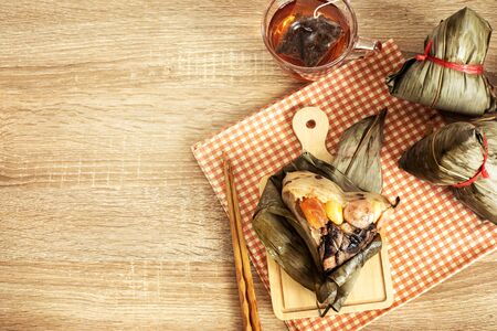Close up Zongzi or rice dumpling on wooden table with Chinese tea in Dragon Boat Festival, Asian traditional food の写真素材