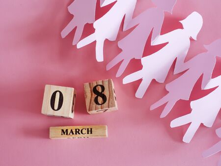 decoration of wooden date blog cube for 8 March , international women's day with paper craft women shape on pink for celebration conceptの写真素材