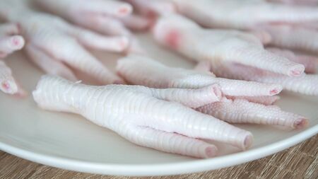 close up fresh raw chicken feet prepared in dish for cooking の写真素材