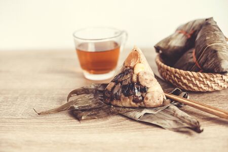 Close up Zongzi or rice dumpling on wooden table with Chinese tea in Dragon Boat Festival, Asian traditional food の写真素材