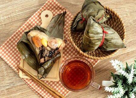 Close up Zongzi or rice dumpling on wooden table with Chinese tea in Dragon Boat Festival, Asian traditional food の写真素材