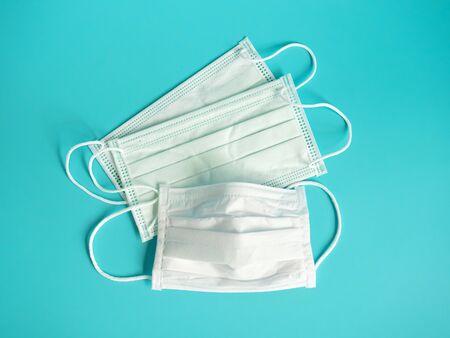 close up white surgical face mask on blue green background , equipment mask to protect man health from flu , coronavirus infection , Health care conceptの写真素材