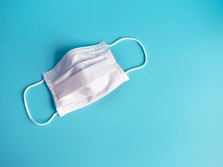 close up white surgical face mask on blue green background , equipment mask to protect man health from flu , coronavirus infection , Health care conceptの写真素材