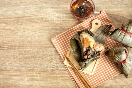 Close up Zongzi or rice dumpling on wooden table with Chinese tea in Dragon Boat Festival, Asian traditional food の写真素材