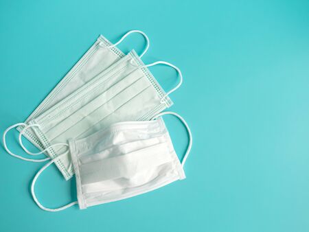 close up white surgical face mask on blue green background , equipment mask to protect man health from flu , coronavirus infection , Health care conceptの写真素材