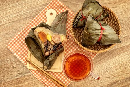 Close up Zongzi or rice dumpling on wooden table with Chinese tea in Dragon Boat Festival, Asian traditional foodの写真素材