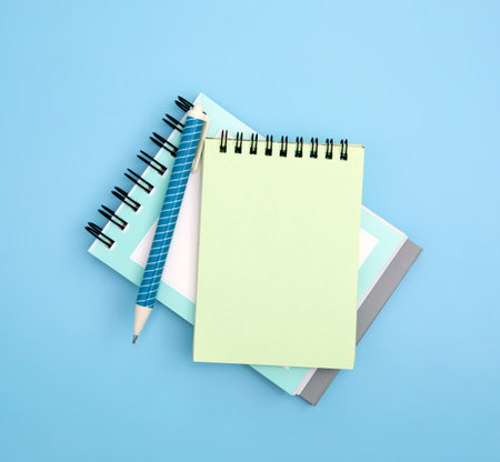 close up  spiral notepad with pen on a blue background , mockup for any text and messageの写真素材