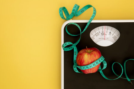 Weight scale and measure tape with fresh apple , Healthy diet for weight loss control conceptの写真素材