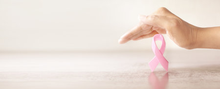 hand cover pink ribbon for Breast Cancer Awareness symbolic, protect and monitor breast cancer promote in October month campaign conceptの写真素材
