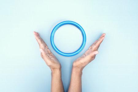 Hand hold up on blue circle symbolic of Diabetes awareness with red drop of blood on light blue background or poster and banner for World Diabetes Day conceptの写真素材