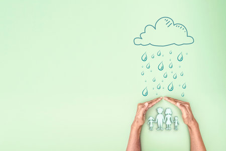 Hand holding covered 3d family symbolic icon protect from cloud and rain, planning family protection by insurance or family care and support conceptの写真素材