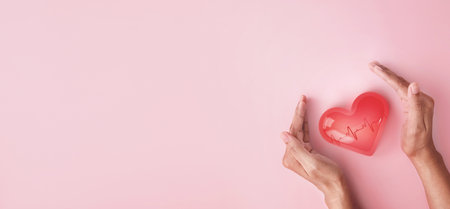 Hand hold 3d transparent heart shape with cardiogram, heart disease awareness campaign, cardiovascular health, Stroke Prevention, hypertension (high blood pressure) for heart disease conceptの写真素材