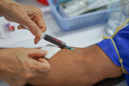 Hand of nurse, doctor or specialist taking blood sample from a patient in the hospital.の写真素材
