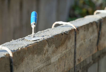 aluminium brick trowel,tool for applying mortar. aluminium brick trowel on new mortar wall (copy space). concept of advertising concrete tools,tile tools,plastering tools etc.の素材 [FY310171186924]