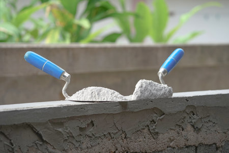 mortar pile on trowels put on a brick block wall in construction site, selective focusの写真素材