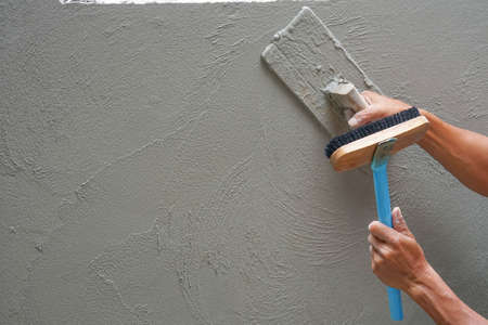 hand of worker plastering cement wall at construction site with copy space, selective focusの写真素材