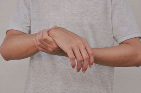 a man support his arms which pain,numbness,weakness,paralysis concept of Guillain barre syndrome caused by autoimmune disorder (selective focus)の写真素材