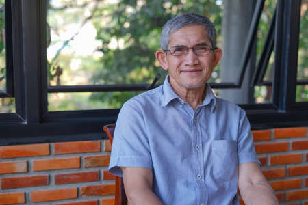 portrait an old man with grey hair sitting casually in the coffee shopの写真素材
