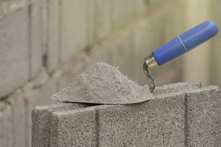 mortar pile on trowel put on a brick block in construction site with copy space for text, selective focusの写真素材