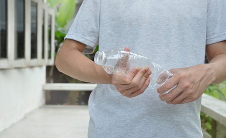 man squeezing plastic bottle. concept to reduce the amount of storage space for plastic bottles for...
