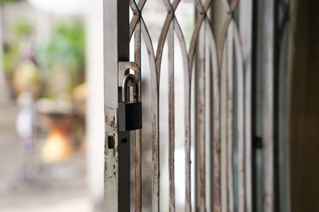 an old unlock metal padlock hanging on an old rusty wrought iron house door, selective focusの写真素材