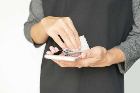 man hand cleaning smartphone screen with grey cloth, selective focus.concept to prevent virus and germsの写真素材
