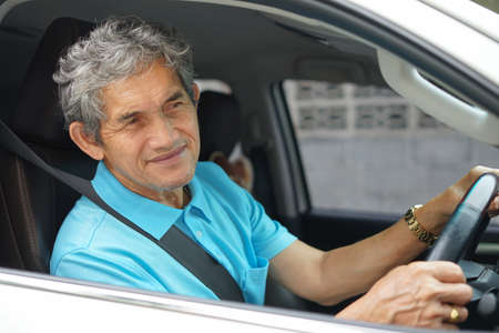 senile man driving a carの写真素材