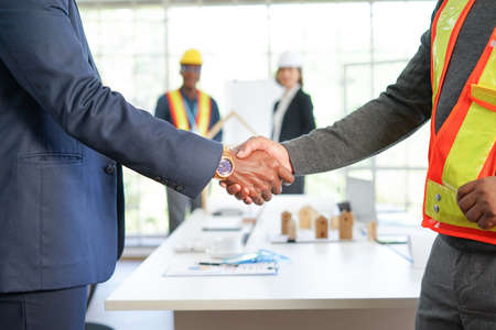 project management engineer and businessman partnership shake hand to joy successful agreement in engineering, architectural or etc.project. business engineering or architecture cooperation concept ect.の写真素材