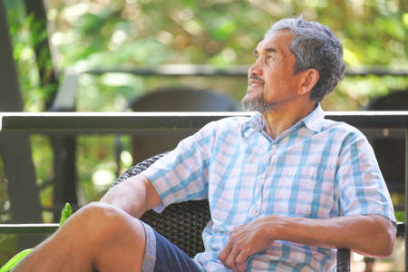 senior man sitting and relaxing in resort garden houseの写真素材