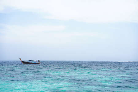 seascape scenery,blue sea water, local fishing boatの写真素材