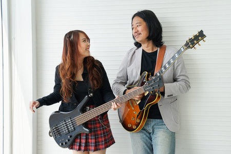 happy duo artist holding guitar before play music,guitarist is playing guitar jam with young student...