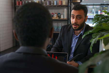 serious multiethnic businessmen discussing work to the partnership at the coffee shopの写真素材